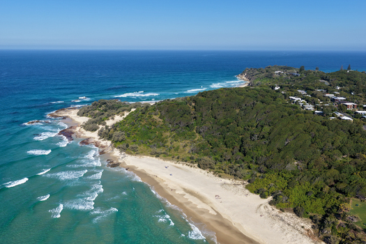 Aerial view of North Stradbroke Island featuring sandy beaches turquoise ocean waves lush green vegetation and coastal houses in Redland City Queensland Australia. Aerial view of North Stradbroke Island featuring sandy beaches turquoise ocean waves lush green vegetation and coastal houses in Redland City Queensland Australia.