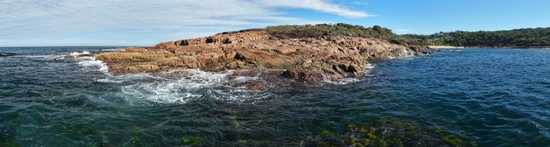 Aerial view of the rugged coastline where ochre cliffs meet the turquoise waters creating a striking contrast of colors and textures New South Wales Australia. Aerial view of the rugged coastline where ochre cliffs meet the turquoise waters creating a striking contrast of colors and textures New South Wales Australia.