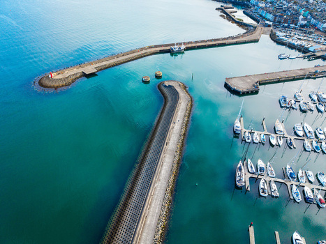 Aerial view of Bangor Harbour and Town featuring a marina filled with sailboats stone breakwaters and the coastal town buildings in Bangor Northern Ireland United Kingdom.