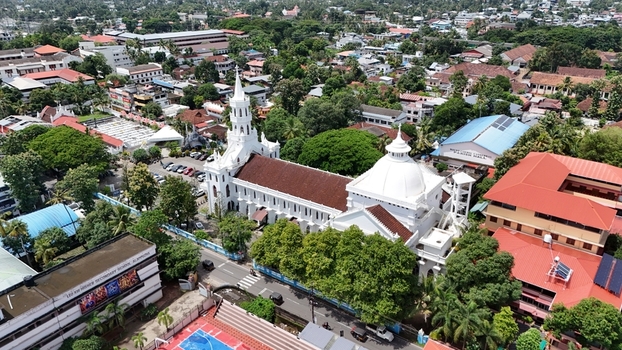 Aerial view of Mount Carmel Roman Catholic Cathedral surrounded by lush green trees and urban rooftops in Alappuzha Kerala India. Aerial view of Mount Carmel Roman Catholic Cathedral surrounded by lush green trees and urban rooftops in Alappuzha Kerala India.