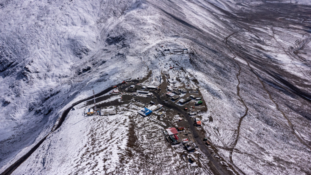 Aerial view of Babusar Pass with snow covered mountain peaks a winding road and small buildings in Babusar KPK Pakistan. Aerial view of Babusar Pass with snow covered mountain peaks a winding road and small buildings in Babusar KPK Pakistan.