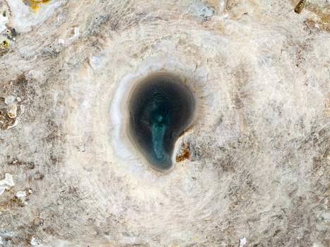 Aerial view of Hveravellir geothermal pool with vibrant mineral deposits and steaming water in Hunabyggd Iceland.