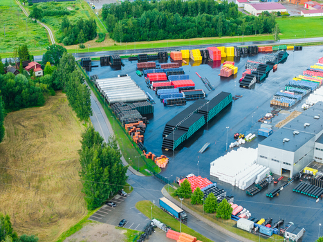 Jelgava Latvia 04 July 2026 Aerial view of a manufacturing facility featuring organized stacks of colorful polymer pipes and industrial components in an outdoor storage yard.