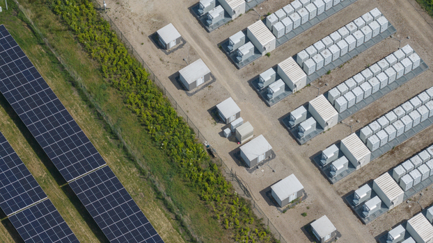 Aerial view of solar panels and a battery energy storage system with rows of white containers and green vegetation Wanneperveen Overijssel Netherlands. Aerial view of solar panels and a battery energy storage system with rows of white containers and green vegetation Wanneperveen Overijssel Netherlands.