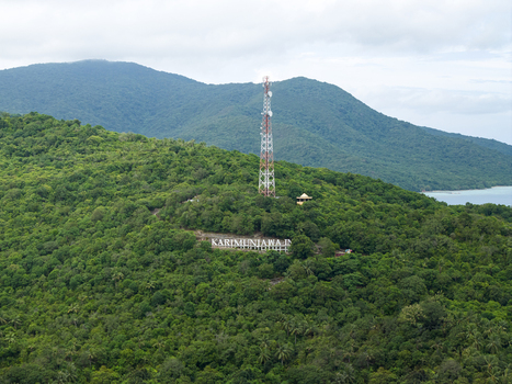 Aerial view of a telecommunications tower rising amidst the verdant hills overlooking the Karimunjawa sign nestled in the lush greenery Karimunjawa Central Java Indonesia. Aerial view of a telecommunications tower rising amidst the verdant hills overlooking the Karimunjawa sign nestled in the lush greenery Karimunjawa Central Java Indonesia.