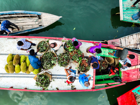 Rangamati Hill District Chittagong Division Bangladesh 18 May 2024 Aerial view of Kaptai Lake with people loading jackfruit onto a wooden boat.