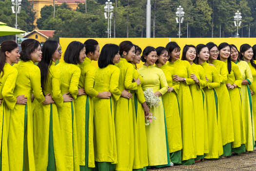 Hanoi Ha Noi Vietnam 11 November 2025 View of a group of women wearing traditional lime green Ao Dai dresses standing in a line outdoors.