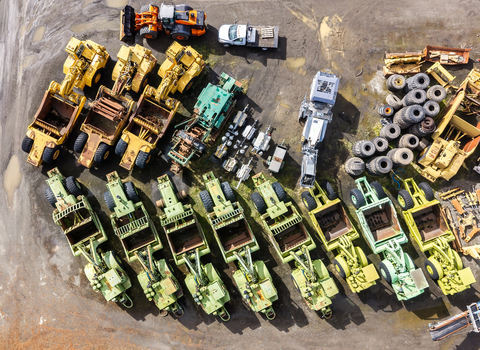 Aerial view of a collection of heavy construction machinery including yellow and green scrapers and tractors parked in a yard with piles of tires in Woodburn Oregon United States. Aerial view of a collection of heavy construction machinery including yellow and green scrapers and tractors parked in a yard with piles of tires in Woodburn Oregon United States.