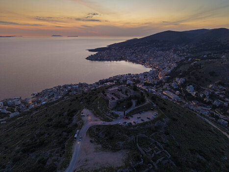 Aerial view of Lekuresi Castle overlooking the coastal city of Saranda and the Ionian Sea at sunset in Saranda Vlore County Albania. Aerial view of Lekuresi Castle overlooking the coastal city of Saranda and the Ionian Sea at sunset in Saranda Vlore County Albania.