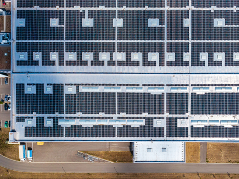 Aerial view of the Glas Troesch Alsace SAS industrial building roof featuring extensive solar panel arrays and skylights in Hombourg Grand Est France.