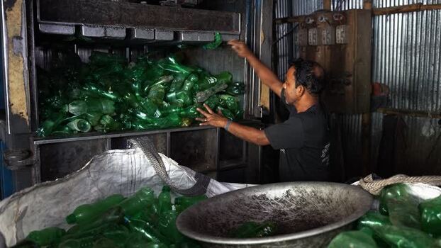 View of a worker recycling plastic bottles in Bogura Bangladesh. View of a worker recycling plastic bottles in Bogura Bangladesh.