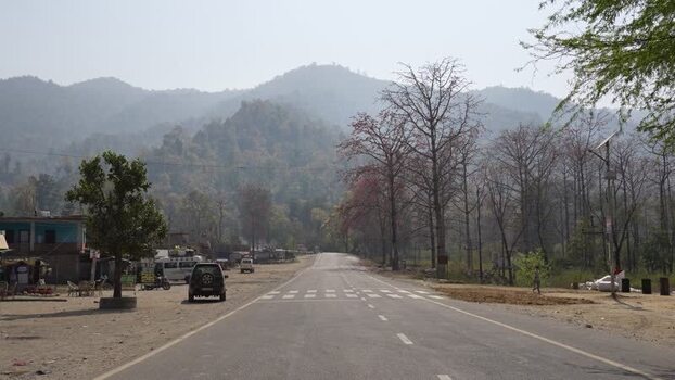 View of a paved road leading towards hazy mountains in Surkhet Nepal. View of a paved road leading towards hazy mountains in Surkhet Nepal.