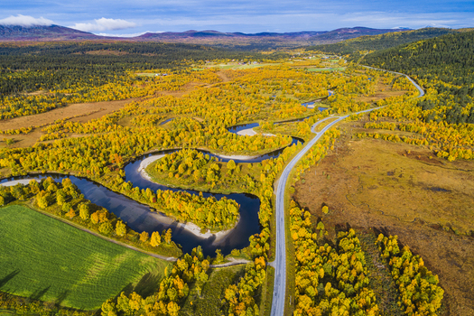 Aerial view of Ljusnan river winding through vibrant autumn colored forests and meadows near the road in Bruksvallarna Jamtland County Sweden. Aerial view of Ljusnan river winding through vibrant autumn colored forests and meadows near the road in Bruksvallarna Jamtland County Sweden.