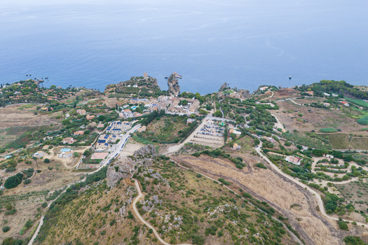 Aerial view of Riserva Naturale Orientata dello Zingaro featuring rugged coastal cliffs Mediterranean vegetation and the town of San Vito Lo Capo Sicilia Italy. Aerial view of Riserva Naturale Orientata dello Zingaro featuring rugged coastal cliffs Mediterranean vegetation and the town of San Vito Lo Capo Sicilia Italy.