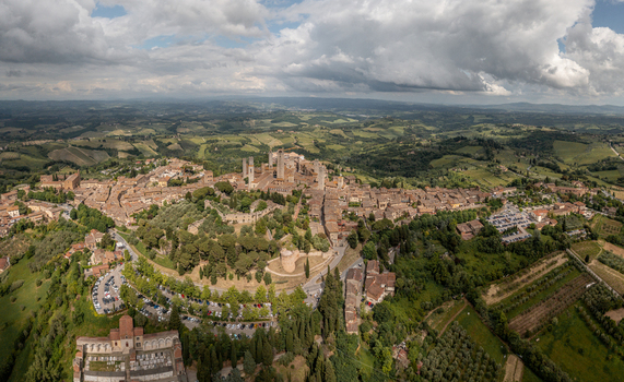 Aerial view of the historic town of San Gimignano with its iconic medieval towers surrounded by rolling hills and vineyards in the Tuscan countryside San Gimignano Tuscany Italy. Aerial view of the historic town of San Gimignano with its iconic medieval towers surrounded by rolling hills and vineyards in the Tuscan countryside San Gimignano Tuscany Italy.