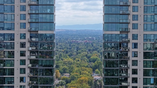 Aerial view of Cherry Creek framed by modern glass skyscrapers with balconies overlooking lush green trees and urban landscape in Denver Colorado United States. Aerial view of Cherry Creek framed by modern glass skyscrapers with balconies overlooking lush green trees and urban landscape in Denver Colorado United States.