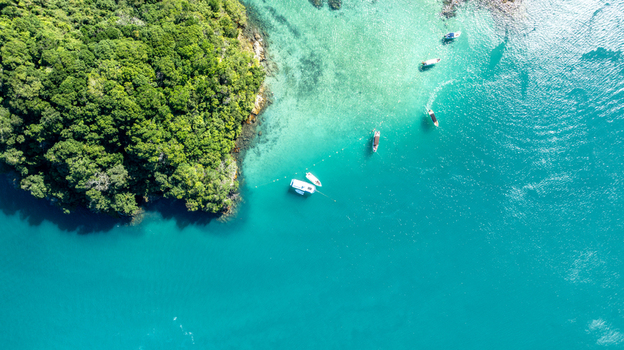 Aerial view of Lagoa Azul with turquoise water and boats anchored near the lush green coastline Angra dos Reis State of Rio de Janeiro Brazil.
