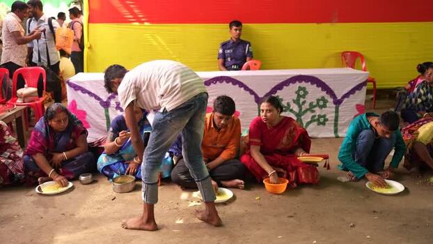 View of people sitting on the ground eating a meal in Bangladesh. View of people sitting on the ground eating a meal in Bangladesh.