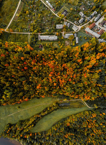 Aerial view of vibrant autumn foliage dense forests residential buildings and winding roads in Sigulda Sigulda Municipality Latvia. Aerial view of vibrant autumn foliage dense forests residential buildings and winding roads in Sigulda Sigulda Municipality Latvia.