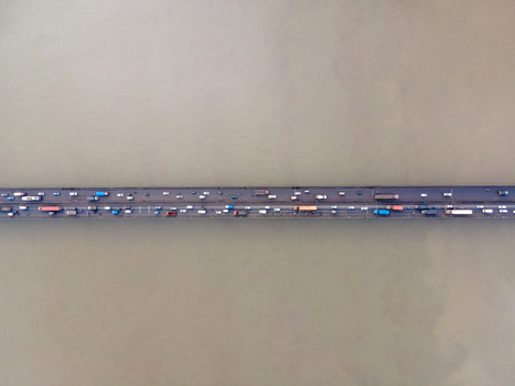 Aerial view of a bridge spanning a wide river with heavy traffic including cars and trucks in Thane Maharashtra India. Aerial view of a bridge spanning a wide river with heavy traffic including cars and trucks in Thane Maharashtra India.