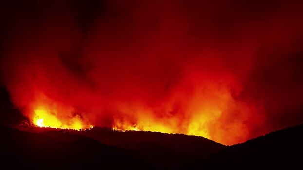 View of wildfire burning on a hillside in Spain.