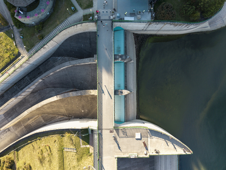 Aerial view of the Niedzica Hydroelectric Power Plant featuring a concrete dam pedestrian walkway turquoise water and people walking in Niedzica Wojewodztwo malopolskie Poland. Aerial view of the Niedzica Hydroelectric Power Plant featuring a concrete dam pedestrian walkway turquoise water and people walking in Niedzica Wojewodztwo malopolskie Poland.