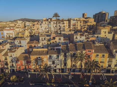 Aerial view of colorful traditional houses and palm trees under a clear blue sky in the historic coastal town of La Vila Joiosa Valencian Community Spain. Aerial view of colorful traditional houses and palm trees under a clear blue sky in the historic coastal town of La Vila Joiosa Valencian Community Spain.