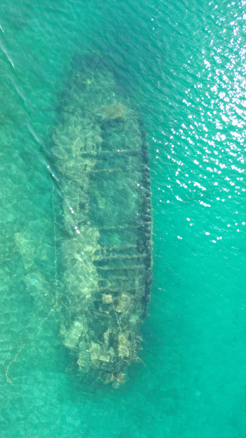 Aerial view of the sunken Kontesa shipwreck resting on the sandy seabed beneath clear turquoise waters in Necujam Split Dalmatia County Croatia. Aerial view of the sunken Kontesa shipwreck resting on the sandy seabed beneath clear turquoise waters in Necujam Split Dalmatia County Croatia.