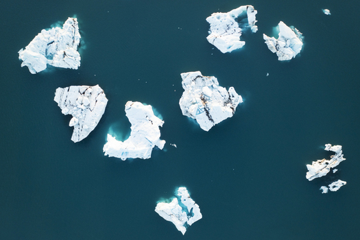 Aerial view of icebergs floating in the Jokulsarlon glacier lagoon with deep blue water in Sveitarfelagid Hornafjordur Iceland. Aerial view of icebergs floating in the Jokulsarlon glacier lagoon with deep blue water in Sveitarfelagid Hornafjordur Iceland.