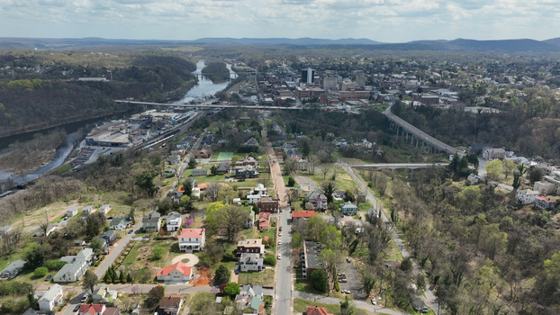 Aerial view of Rivermont Avenue in spring featuring historic residential houses lush green trees and the James River winding through Lynchburg Virginia United States.