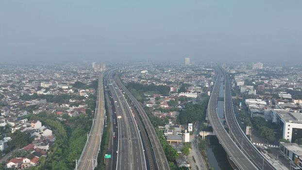 Aerial view of the highway infrastructure winding through the dense urban landscape of Bekasi Barat West Java Indonesia. Aerial view of the highway infrastructure winding through the dense urban landscape of Bekasi Barat West Java Indonesia.