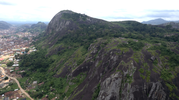 Aerial view of Idanre Hill featuring massive rocky formations lush tropical vegetation and the surrounding town of Idanre Ondo State Nigeria. Aerial view of Idanre Hill featuring massive rocky formations lush tropical vegetation and the surrounding town of Idanre Ondo State Nigeria.