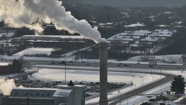 Aerial view of industrial smokestack emitting smoke in winter United States. Aerial view of industrial smokestack emitting smoke in winter United States.