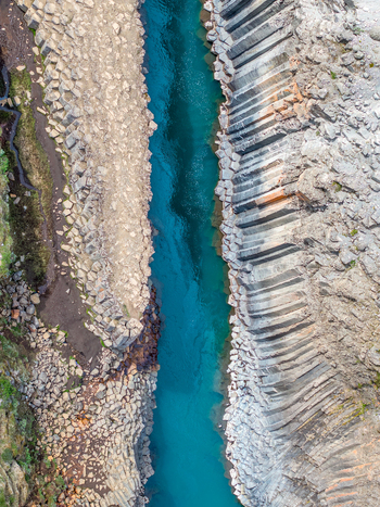 Aerial view of the basalt columns lining the turquoise river in Studlagil Canyon Iceland. Aerial view of the basalt columns lining the turquoise river in Studlagil Canyon Iceland.