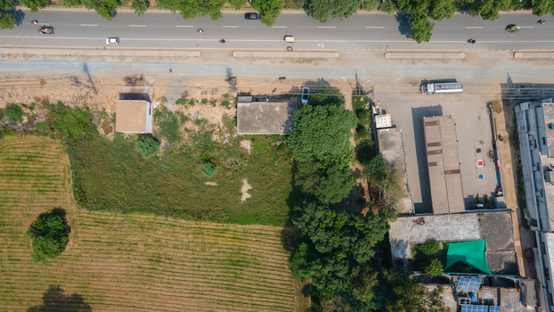 Lahore Pakistan 08 September 2026 Aerial view of the urban landscape featuring a road agricultural fields and nearby buildings in Punjab.