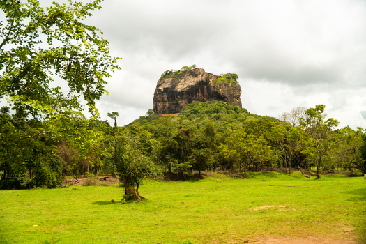 View of the ancient Sigiriya Rock fortress rising above lush tropical forests under a cloudy sky Sigiriya Central Province Sri Lanka. View of the ancient Sigiriya Rock fortress rising above lush tropical forests under a cloudy sky Sigiriya Central Province Sri Lanka.