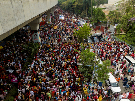 Dhaka Bangladesh 13 April 2026 Aerial view of a vibrant sea of humanity flowing along a bustling city street a kaleidoscope of traditional attire beneath a stark concrete overpass.