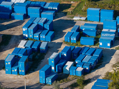 Aerial view of numerous blue shipping containers arranged in an industrial storage yard with gravel ground and shadows cast by the afternoon sun in Nera Montoro Umbria Italy. Aerial view of numerous blue shipping containers arranged in an industrial storage yard with gravel ground and shadows cast by the afternoon sun in Nera Montoro Umbria Italy.