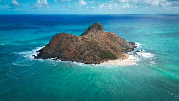Aerial view of a rugged island with a prominent peak surrounded by turquoise waters and a sandy beach Kailua Hawaii United States. Aerial view of a rugged island with a prominent peak surrounded by turquoise waters and a sandy beach Kailua Hawaii United States.