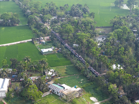 Dhaka Bangladesh 27 March 2026 Aerial view of a bustling bridge teeming with a multitude of people connecting vibrant green fields and lush trees. Dhaka Bangladesh 27 March 2026 Aerial view of a bustling bridge teeming with a multitude of people connecting vibrant green fields and lush trees.
