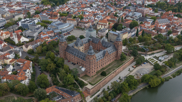 Aerial view of the historic Schloss Johannisburg with its red sandstone architecture and courtyard overlooking the Main river and the urban landscape of Aschaffenburg Bayern Germany.