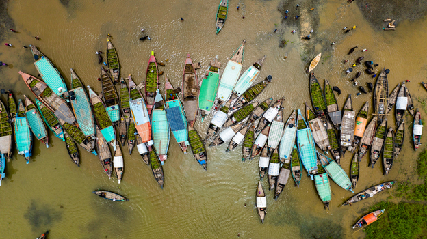 Aerial view of Baish Mowza Sarak Bazar with numerous wooden boats carrying goods on the river in Nabinagar Chittagong Division Bangladesh. Aerial view of Baish Mowza Sarak Bazar with numerous wooden boats carrying goods on the river in Nabinagar Chittagong Division Bangladesh.