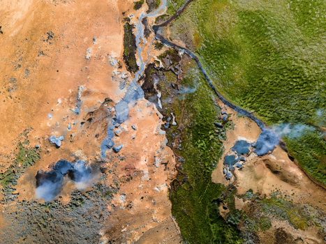 Aerial view of the geothermal landscape of Grensdalur featuring steaming vents colorful mineral deposits and vibrant green mossy terrain in Sveitarfelagid Olfus Iceland. Aerial view of the geothermal landscape of Grensdalur featuring steaming vents colorful mineral deposits and vibrant green mossy terrain in Sveitarfelagid Olfus Iceland.