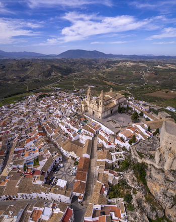 Aerial view of the town of Olvera featuring the prominent Church of Our Lady of the Incarnation and historic castle ruins surrounded by white washed houses in Olvera Andalusia Spain. Aerial view of the town of Olvera featuring the prominent Church of Our Lady of the Incarnation and historic castle ruins surrounded by white washed houses in Olvera Andalusia Spain.