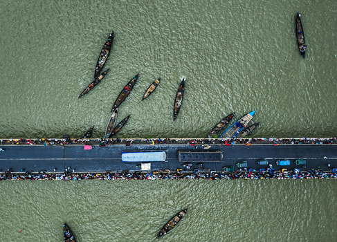 Baghabari Rajshahi Division Bangladesh 20 August 2022 Aerial view of Baghabari bridge over the river with small wooden boats people walking and vehicles crossing.