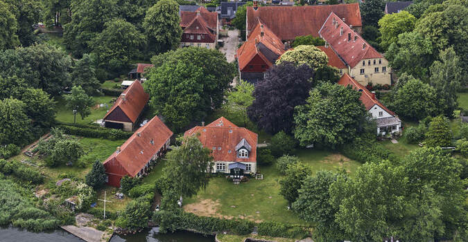 Schleswig Germany 01 July 2026 Aerial view of St Johannis kloster a historic cloister in Schleswig Holstein with red tiled roofs lush gardens and trees near the Schlei.