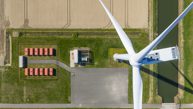 Aerial view of battery storage system at wind park with wind turbines
