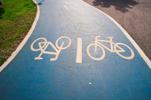 View of a blue painted bicycle lane with white bicycle symbols on the asphalt in Helsinki Uusimaa Finland.