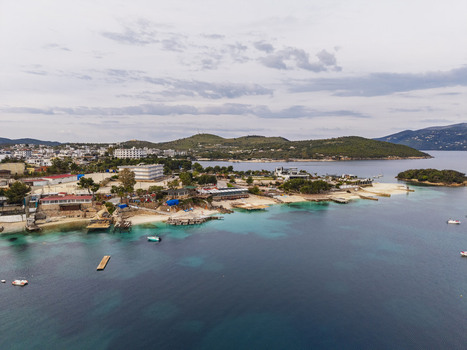 Aerial view of the coastal town of Ksamil with turquoise waters sandy beaches small islands and buildings set against rolling hills in Ksamil Vlore County Albania. Aerial view of the coastal town of Ksamil with turquoise waters sandy beaches small islands and buildings set against rolling hills in Ksamil Vlore County Albania.