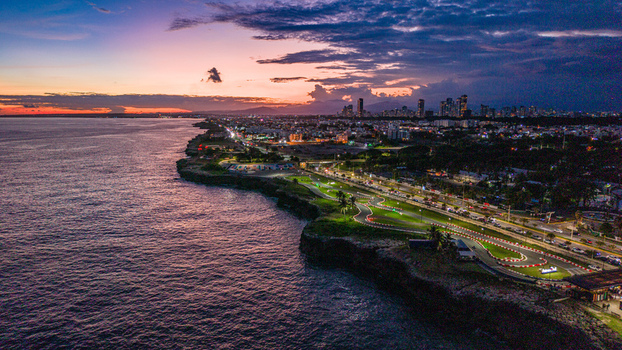 Aerial view of the Feria Ganadera area along the coastline at sunset with the city skyline in the distance in Santo Domingo Distrito Nacional Dominican Republic. Aerial view of the Feria Ganadera area along the coastline at sunset with the city skyline in the distance in Santo Domingo Distrito Nacional Dominican Republic.